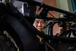 © Martin - Focused photo of an Asian man's face through a hole in the chassis of a motorcycle.