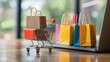 © Sariyono - Colorful Shopping Bags in a Mini Cart on Laptop
