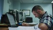 © Felippe Lopes - Focused male employee filling out paperwork at his desk in a modern office setting