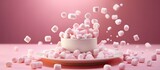 Delicate dessert of marshmallows falling on a pink background plate with copy space image.