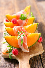 Sticker - Fresh sweet orange melon and prosciutto ham on wooden board