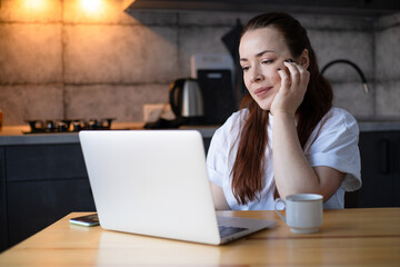 Work on the kitchen office. Remote work from home office. Young woman making videocall. Freelancer workplace at kitchen table. Distance education