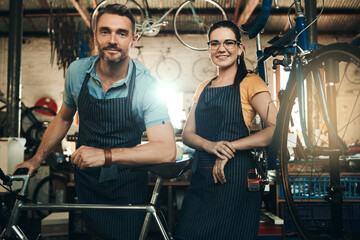 Wall Mural - Portrait, people and bicycle repair shop with smile from mechanic, technician and maintenance work. Workshop, service and happy business owner with staff and bike for fixing with apron and pride