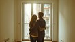 © Irina Ukrainets - Couple embracing in new apartment. Sunlight streaming through large windows. Modern home with empty room. Warm, inviting atmosphere. Ideal for real estate, lifestyle, and home decor themes. AI