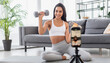 © franzdell - ragazza che fa palestra esercizi davanti smartphone in diretta streaming influencer