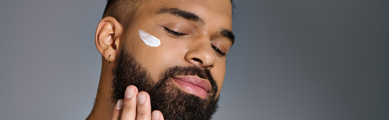 Wall Mural - A handsome young man with a beard and a lot of cream on his face.