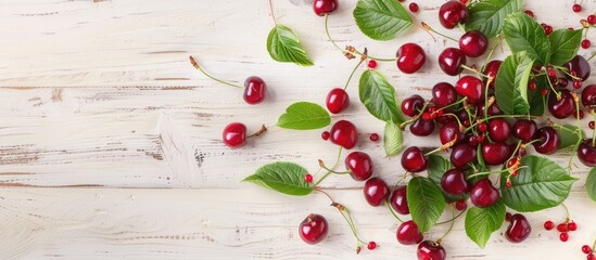 Wall Mural - Juicy cherries with vibrant green leaves on a light wooden backdrop, viewed from above with space for text. Capturing the essence of summertime fruits and berries.