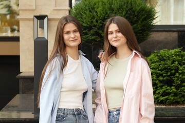 Canvas Print - Portrait of two beautiful twin sisters outdoors