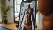 © Prostock-studio - A close-up of a persons hand holding a smartphone, displaying a fitness app featuring a female model in a sports bra and underwear. The background is a blurred living room setting.