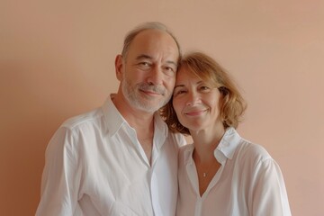 Wall Mural - Portrait of a content couple in their 50s wearing a classic white shirt over pastel or soft colors background