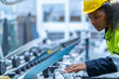 © ultramansk - Portrait of African woman worker beautiful face with eye confident and wearing working suite dress and safety helmet at heavy machine in industry factory. Engineer  worker concentrate on workplace.