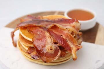 Wall Mural - Delicious pancakes with bacon and honey on white table, closeup