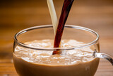ガラスのカップに牛乳とコーヒーを入れてつくるカフェオレ
