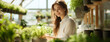 © Sudarshana - Wide banner image of cute happy farmer lady in front of a greenhouse with pretty smile