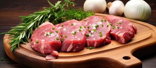 Fototapete - Raw beef and pork fillet pieces with garlic and herbs on a wooden surface, isolated on white background. with copy space image. Place for adding text or design
