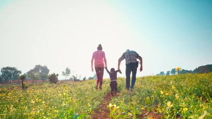 Parents playing with their son in the field on the way home