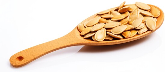 Poster - Wooden spoon lays filled with pumpkin seeds on a plain white table. with copy space image. Place for adding text or design