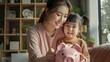 © dobok - mother and daughter hold piggy bank at home