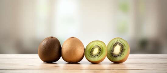 Aufkleber - Three whole kiwi fruits and a half of a kiwi fruit placed on a tabletop. with copy space image. Place for adding text or design