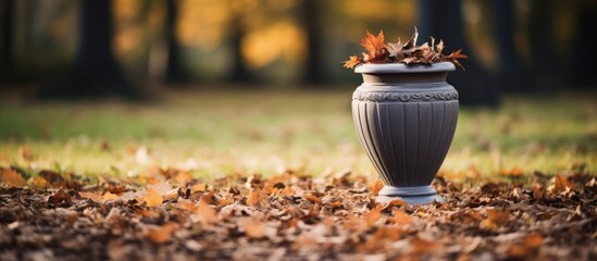 Aufkleber - Vase on the ground containing leaves, placed outdoors at a park in late autumn. with copy space image. Place for adding text or design