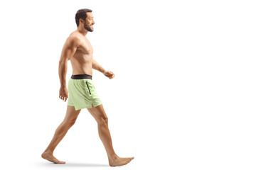 Sticker - Full length profile shot of a man in swimming shorts walking