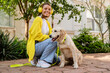 © mary_markevich - happy smiling woman in yellow sweater walking at her house with a dog golden retriever