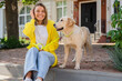 © mary_markevich - happy smiling woman in yellow sweater walking at her house with a dog golden retriever