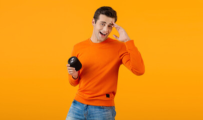 stylish young man holding wireless speaker