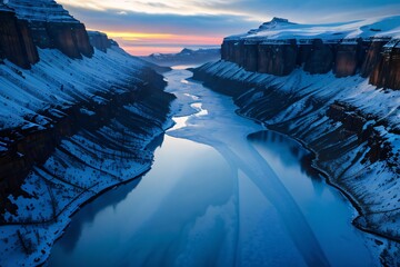 Wall Mural - Snow-capped mountains reflected in a frozen lake under a colorful sunset sky.