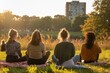 © ylivdesign - Four friends enjoying a peaceful evening in a city park at sunset