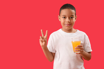 Sticker - Little African-American boy with glass of orange juice showing victory gesture on red background