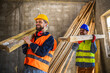 © Mediteraneo - Two construction workers carrying a scaffolding at a building site - people at work concepts