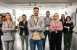 © Mediteraneo - Portrait of young CEO businessman standing  with his hands crossed in front of his colleagues.