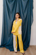 © Tania Cervian/Stocksy - Woman standing in yellow clothes