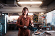 © Ibai Acevedo/Stocksy - Female mechanic looking at camera at metal workshop