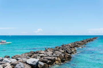 Poster - Beautiful sunny day with rocks going out into the ocean