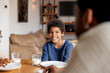 © Jovo Jovanovic/Stocksy - Happy boy having breakfast with father at home