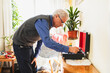 © Diego Martin/Stocksy - Senior man listening to vinyl disc at home