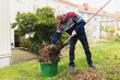 © Diego Martin/Stocksy - Senior man cleaning with wire broom his garden