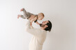 © Lea Jones/Stocksy - portrait of  happy father  with smiling baby in studio