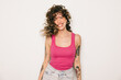 © VICTOR TORRES/Stocksy - Joyful tattooed woman in pink top laughing against white background