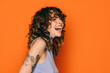 © VICTOR TORRES/Stocksy - Joyful young woman laughing on bright orange background