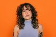 © VICTOR TORRES/Stocksy - Stylish young woman with tattoos against orange background