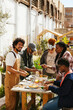© BONNINSTUDIO/Stocksy - Diverse friends having lunch in community garden