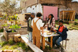 © BONNINSTUDIO/Stocksy - Diverse friends having lunch in community garden