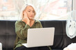 © Pixel-Shot - Mature businesswoman with laptop experiencing menopause on couch in office