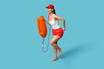 Wall Mural - Female lifeguard with rescue tube buoy running on blue background