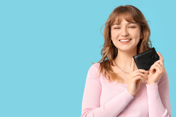 Sticker - Beautiful young woman holding black wallet on blue background