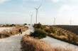 © Irina Polonina/Stocksy - Hiker Approaching Wind Turbines at Dusk