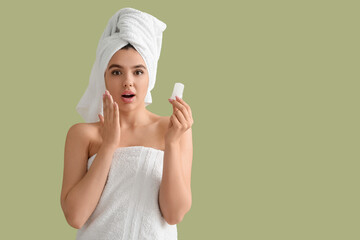 Wall Mural - Surprised young woman in towel with crystal deodorant on green background